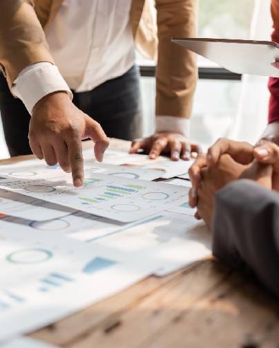 Business team discussing charts and data on a table.
