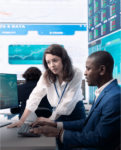 Two professionals analyzing data on computer screens in an office.