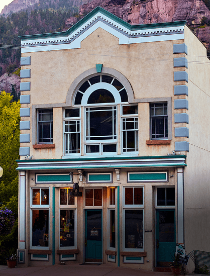 Historic building with arched window and wooden shutters.