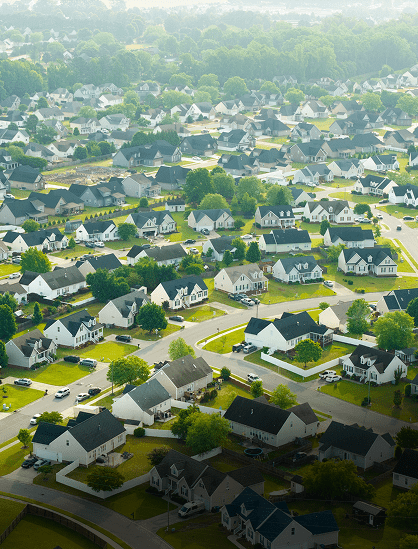 Aerial view of a suburban neighborhood with many houses and green lawns.
